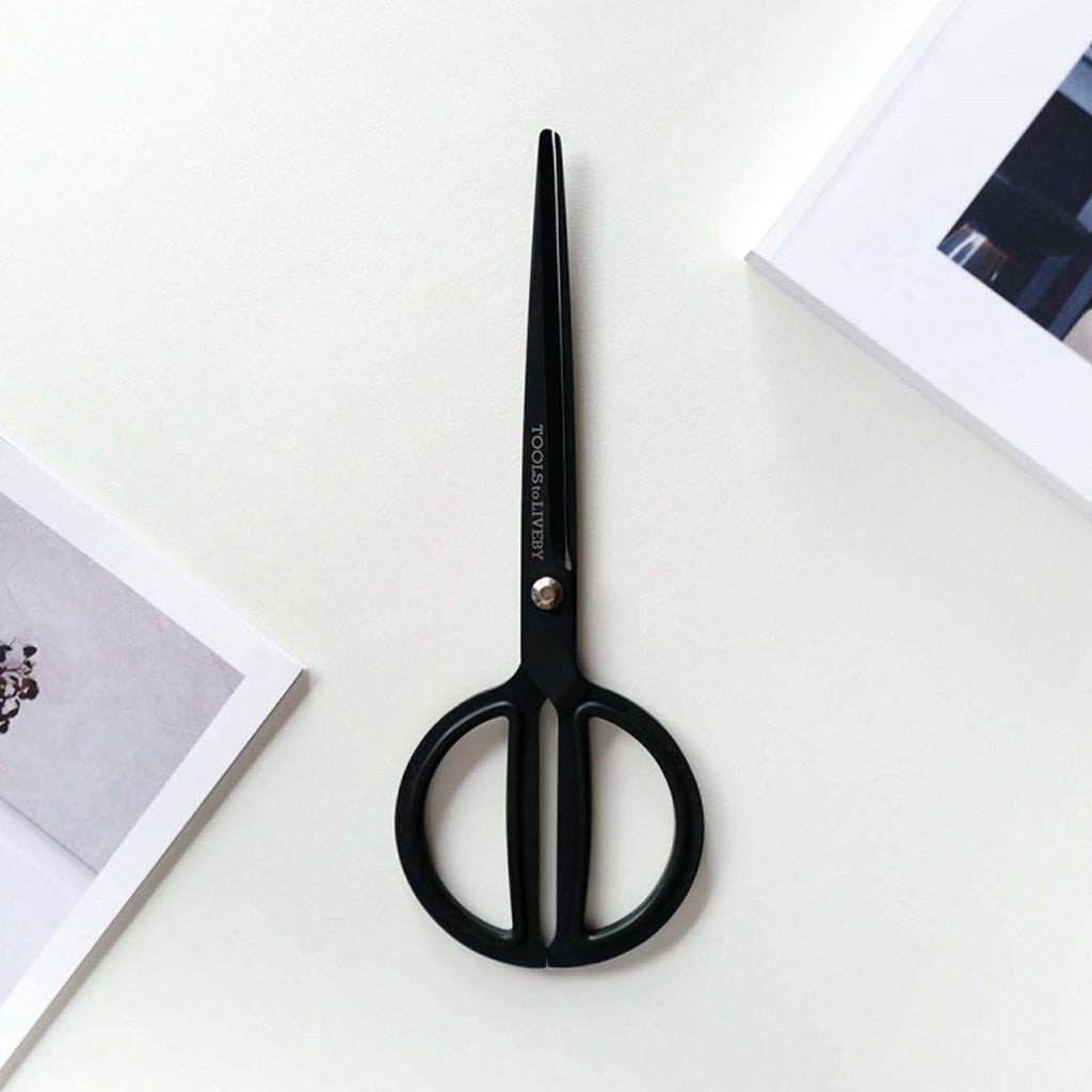 Matte black scissors with rounded handles on white background