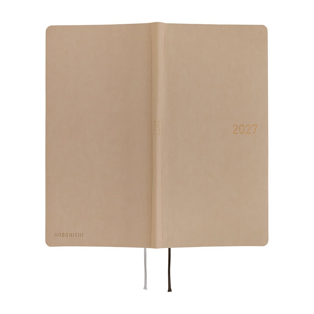 An exterior view of a planner with a sandy beige softcover that is flexible and slightly puffy. The year 2027 is embossed in gold on the front.