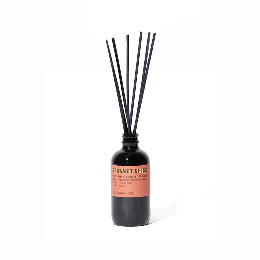 Bergamot shiso reed diffuser bottle with black reeds on white background