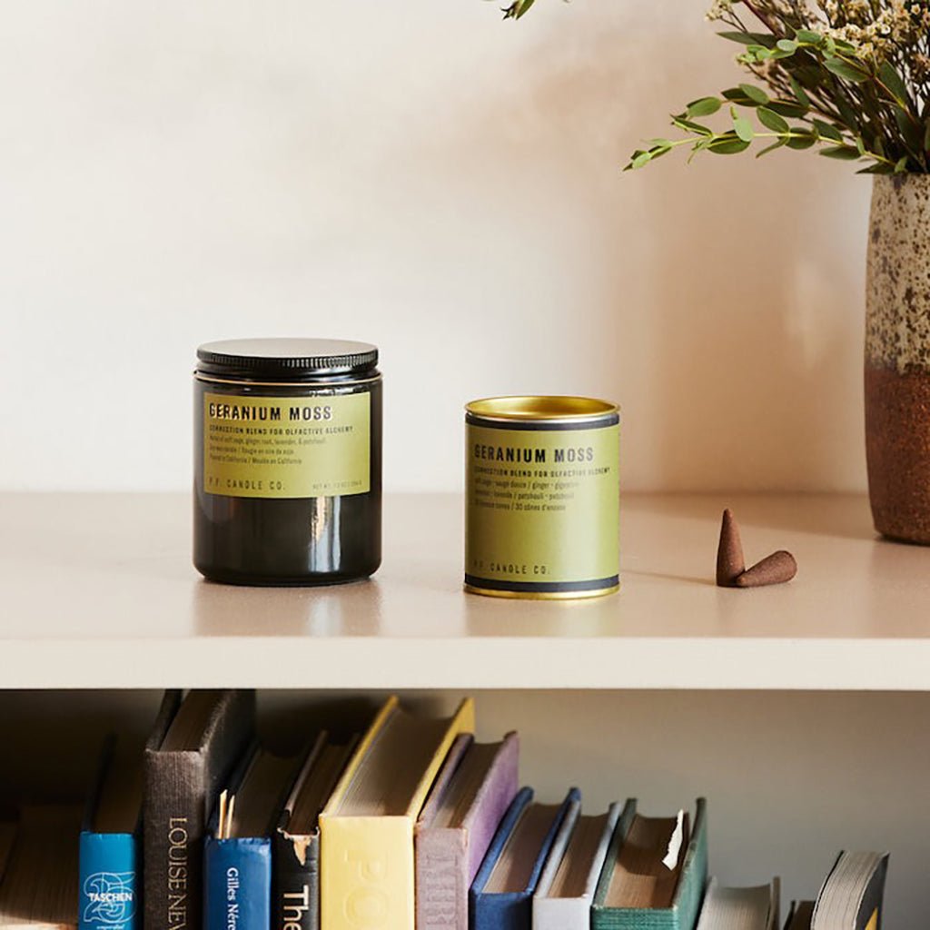 Geranium Moss candle and incense cones on shelf above books