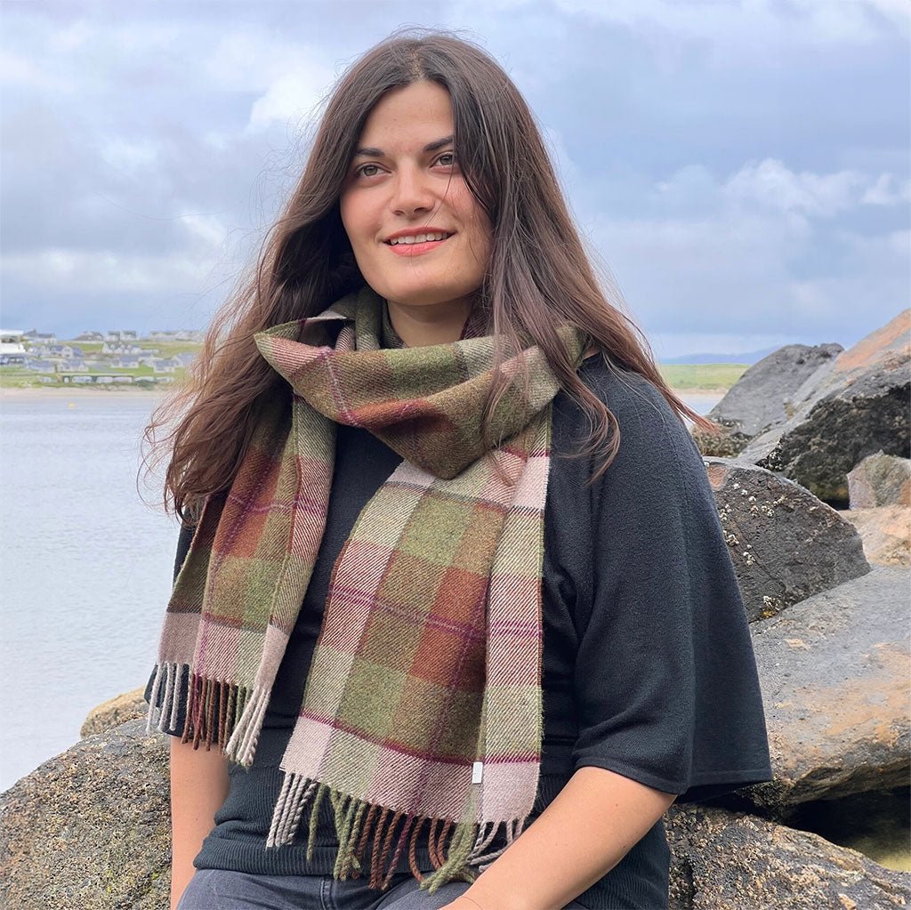 Woman wearing Autumn Plaid wool scarf in front of natural setting.