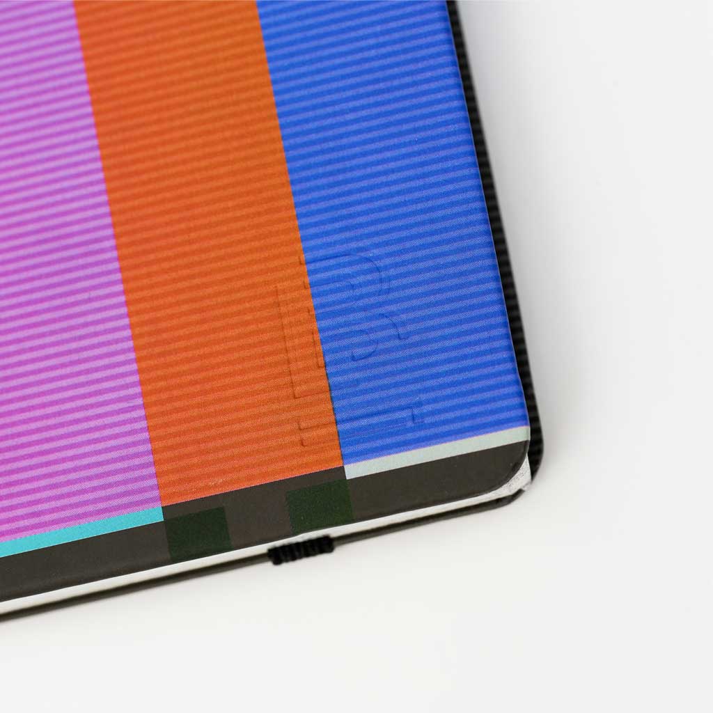 Close up of Blackwing 343 notebook with color bar cover and Blackwing imprint on white background