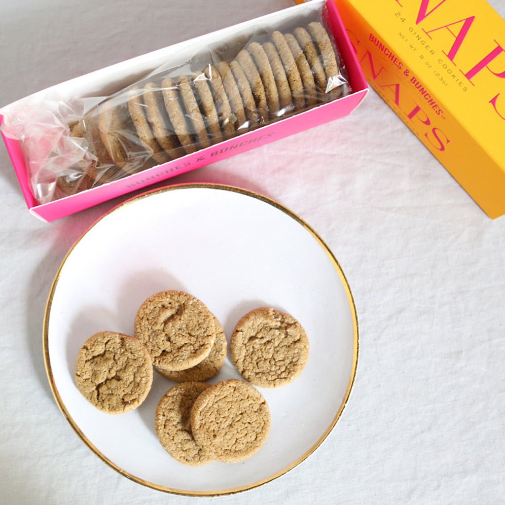 Ginger snap cookies next to open box with sleeve of cookies.