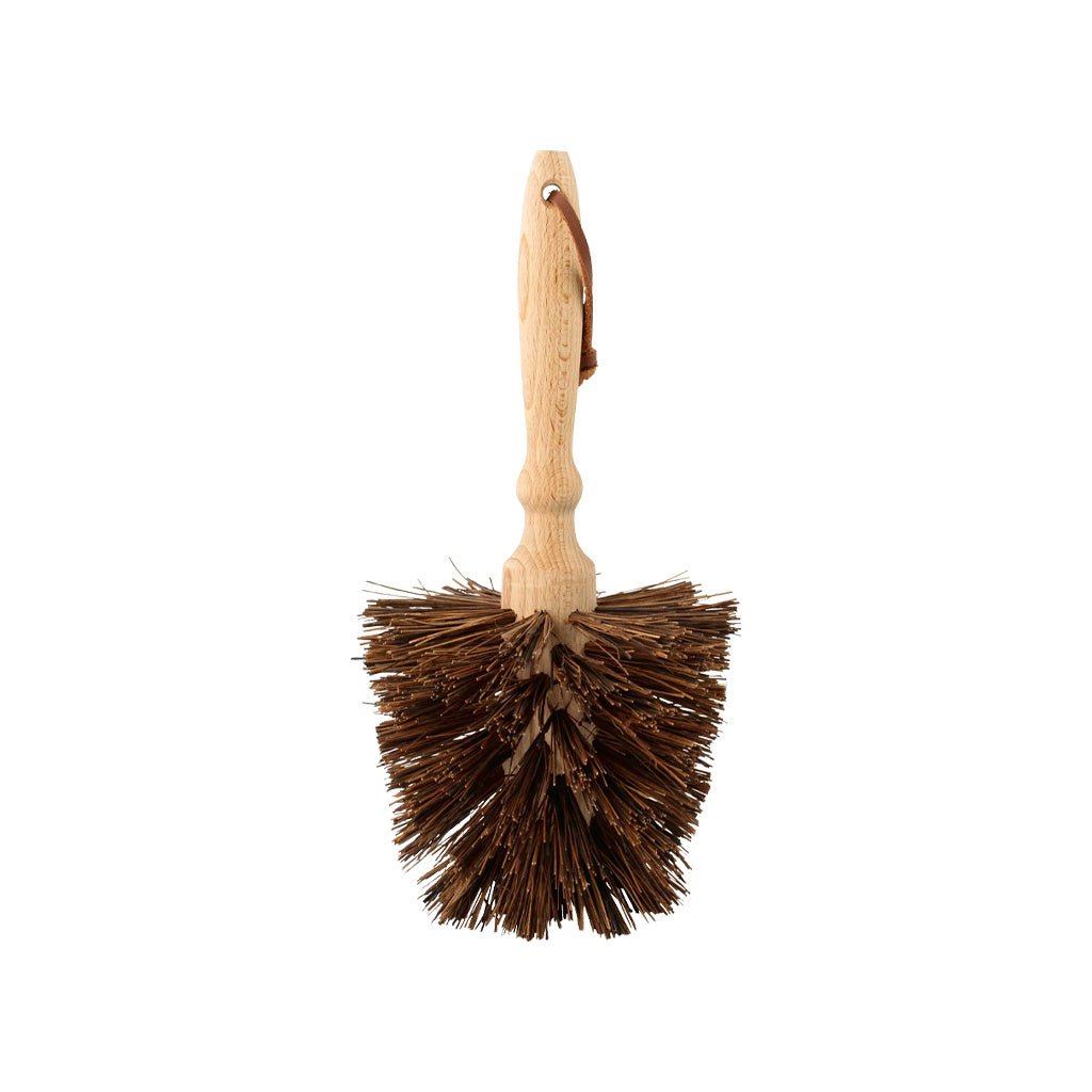 Wooden flower pot brush with natural bassine fibers and leather loop on white background