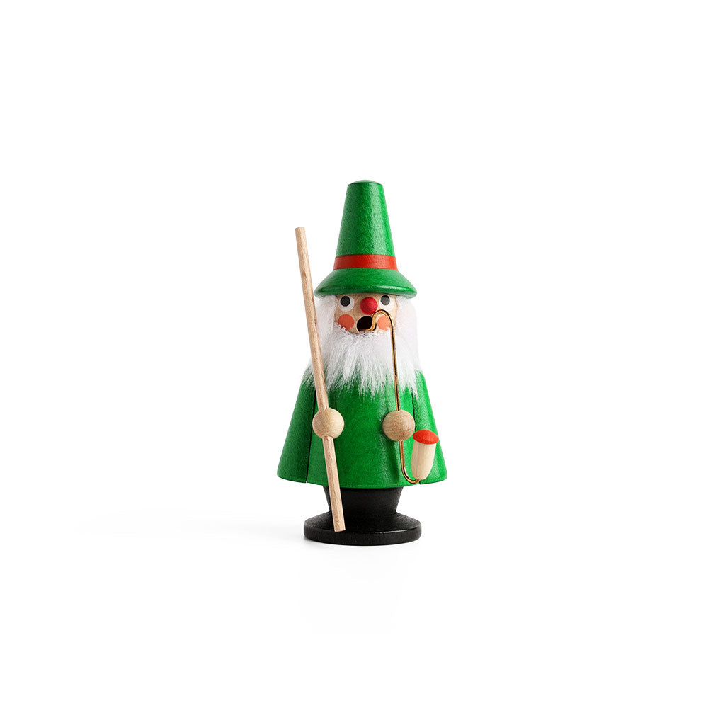 A small wooden gnome incense smoker figurine dressed in green, with a white beard, holding a staff and a pipe.