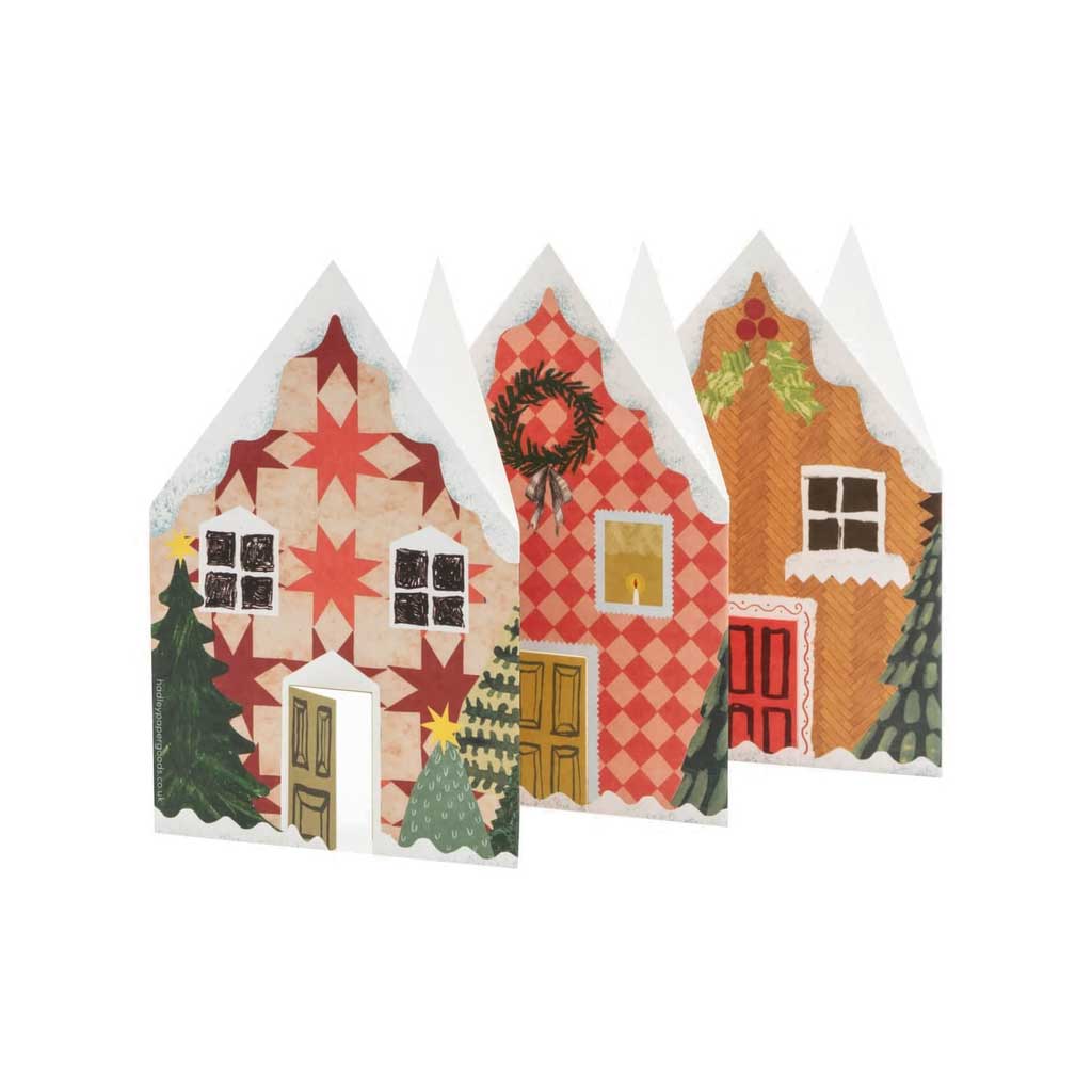 Three decorative paper houses with Christmas patterns on a white background