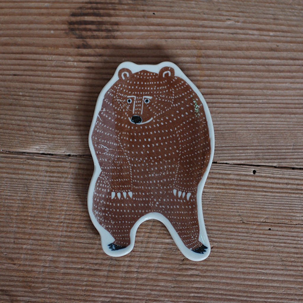 Brown bear-shaped ceramic dish on wooden background