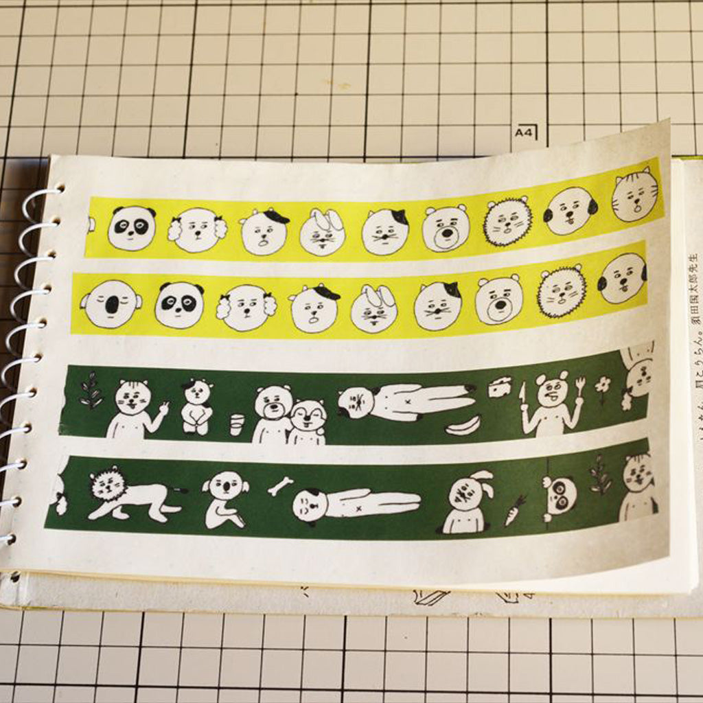 A spiral-bound notebook page showing four horizontal strips of illustrated washi tape. The top two strips are yellow and the bottom two are dark green, each decorated with white cartoon animal faces and simple drawings.