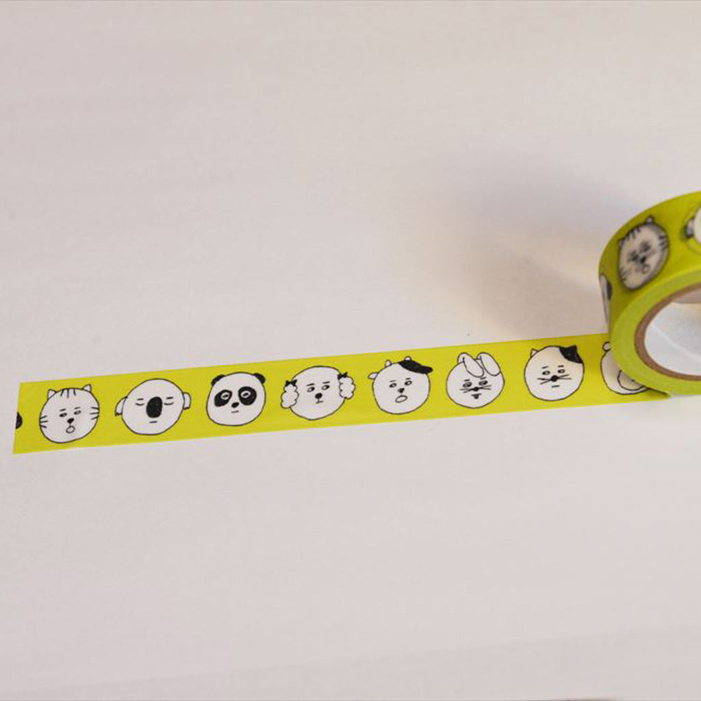 Yellow washi tape with cartoon animal faces, shown partially unrolled from a roll on a plain white background.