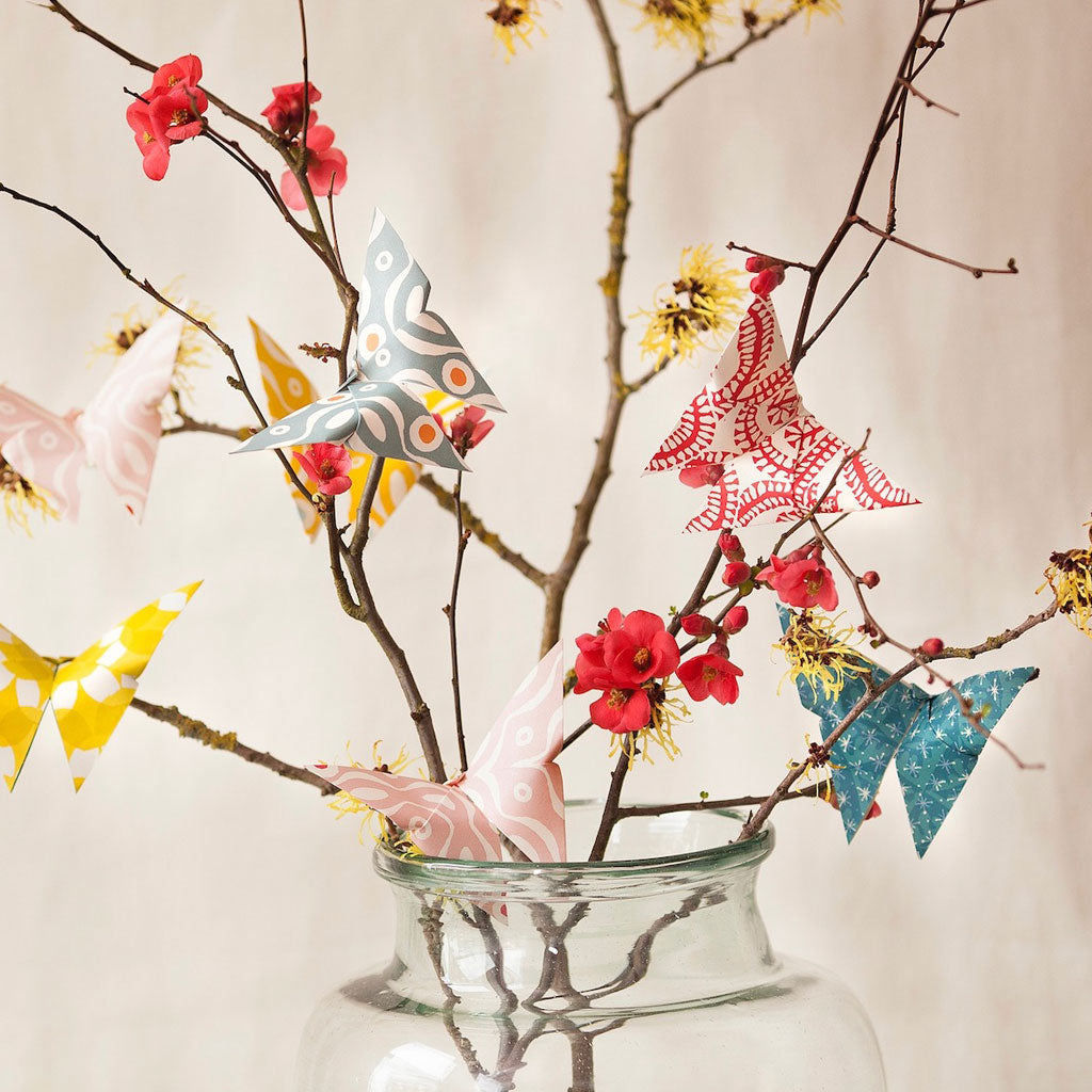 Assortment of origami butterflies attached to branches