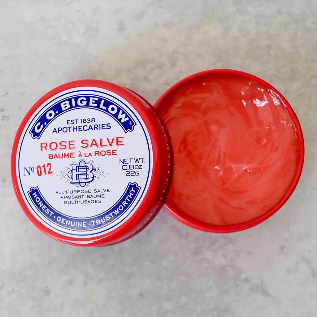 A tin of C.O. Bigelow Rose Salve with lid open showing the red balm inside.