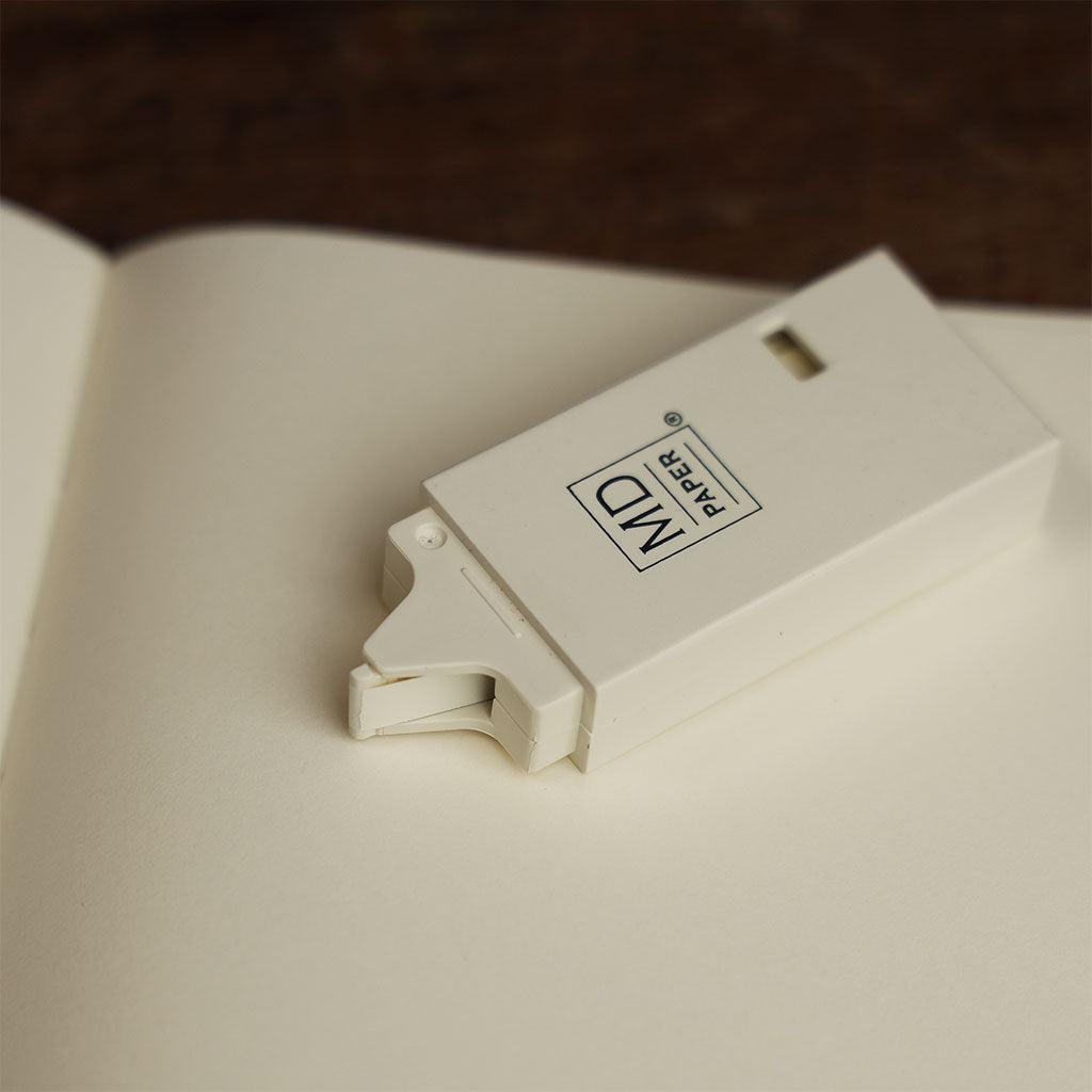 Close up of midori cream correction tape resting on cream midori paper