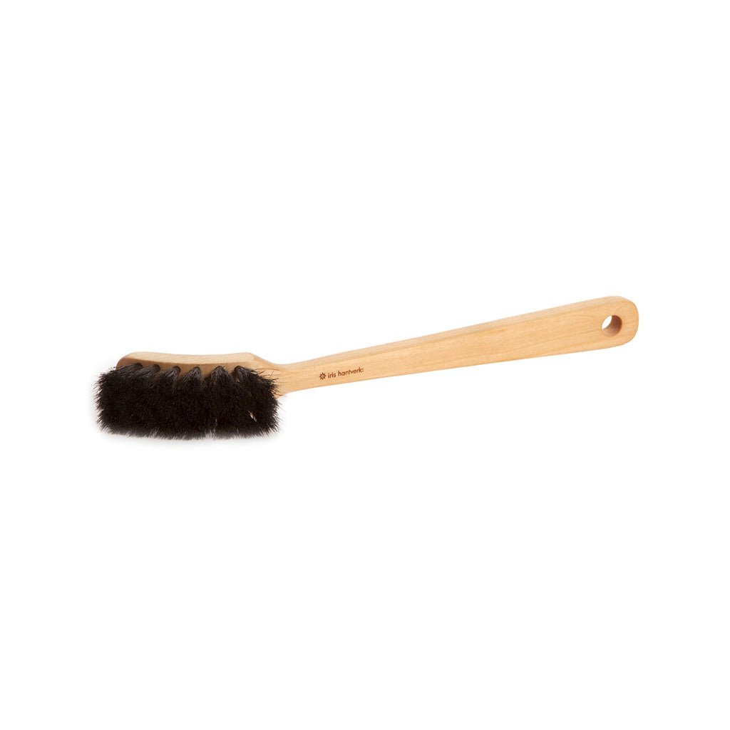 A wooden dish brush with dark bristles on white background.
