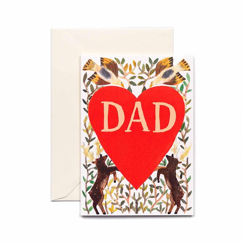 A greeting card with a large red heart and the word 'DAD' in white letters, surrounded by a floral and animal pattern. The card is held by a white envelope.
