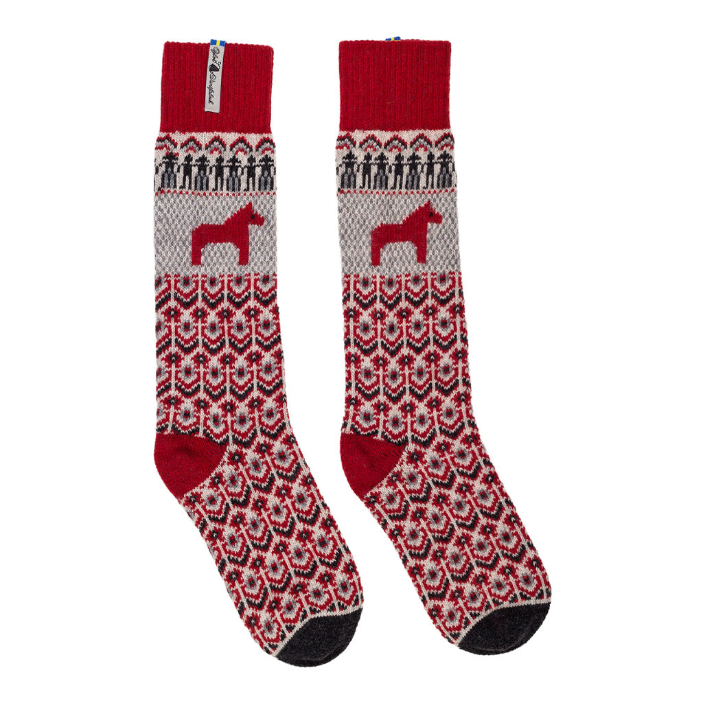A pair of tall wool socks with a traditional Nordic pattern in red, gray, and black, featuring a red horse silhouette on a gray section.