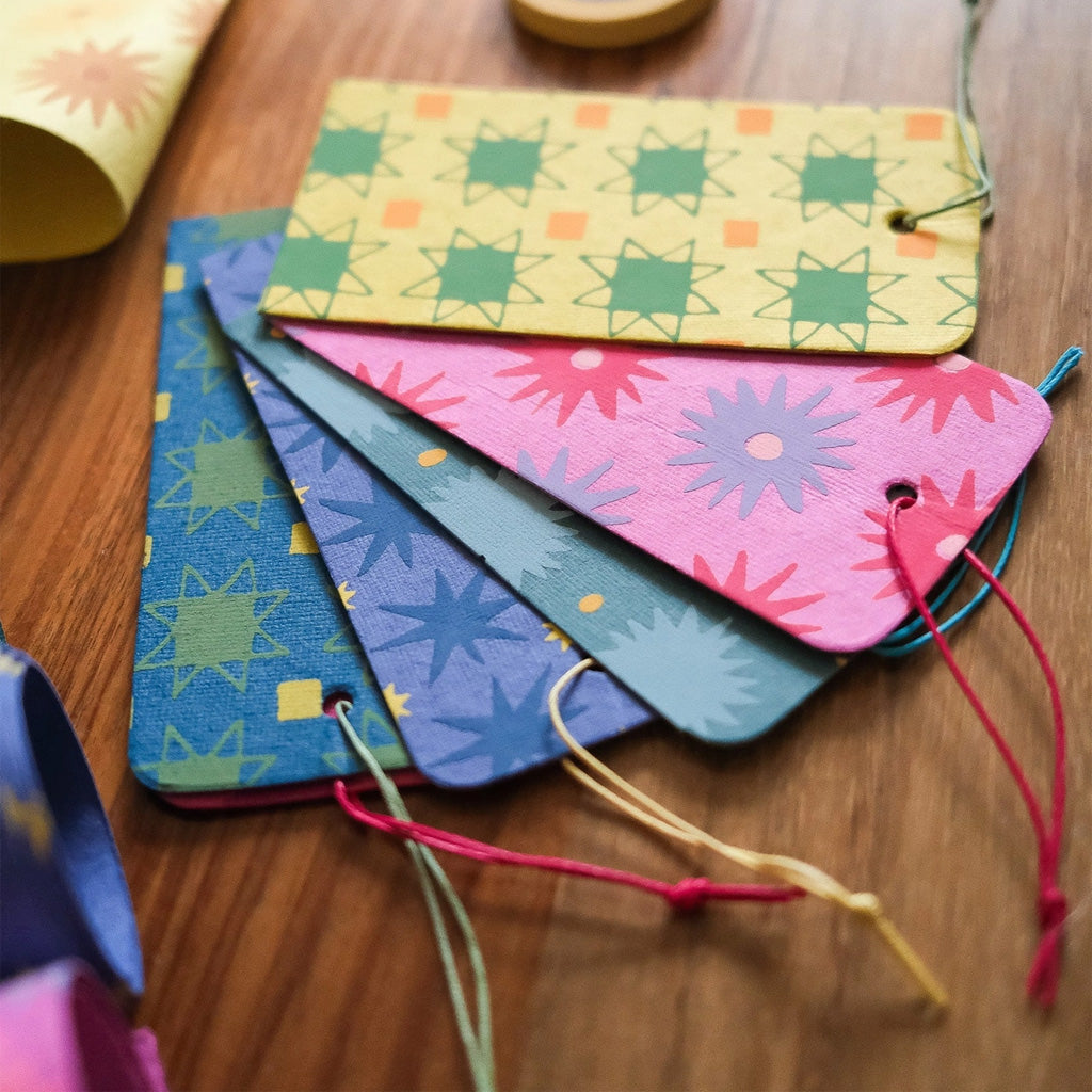 Paper gift tags with strings laying on wooden table.