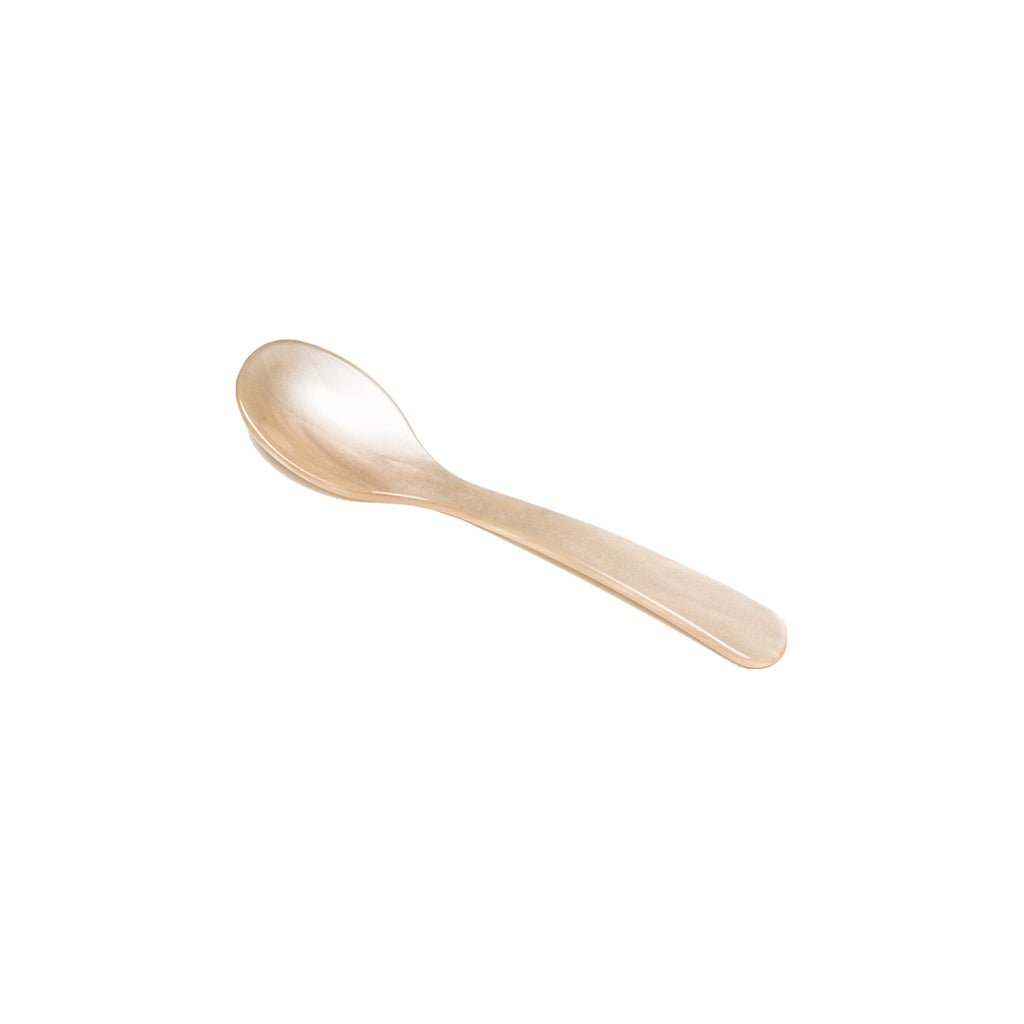 Cream colored acrylic egg spoon on white background