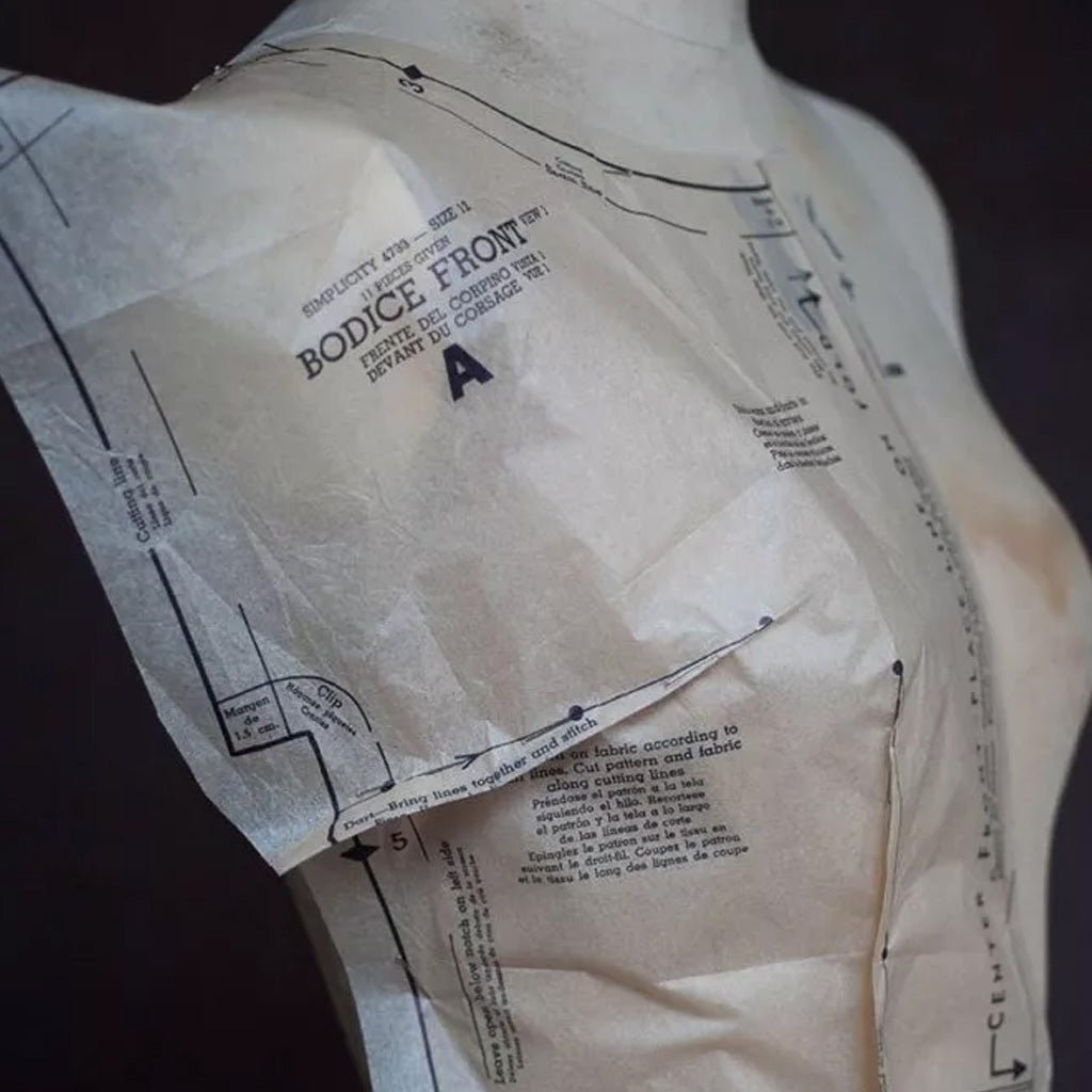 Pattern paper on a dress form with sewing instructions.