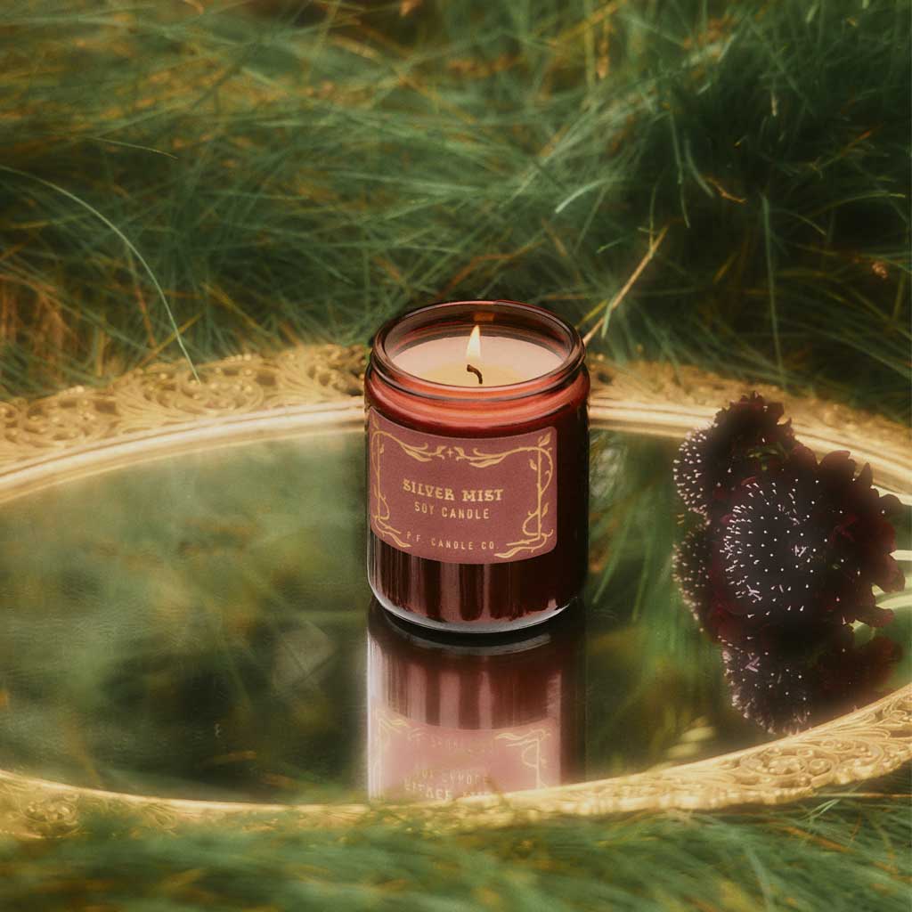 Candle in a decorative container with a natural background