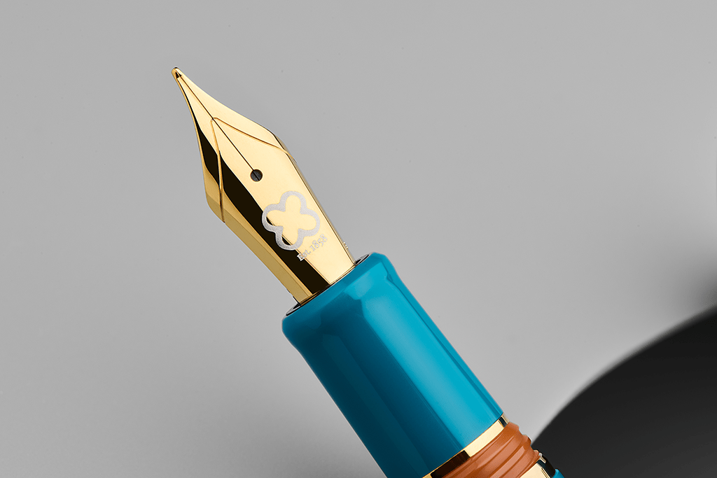 Close-up of a blue fountain pen with gold accents on a gray background