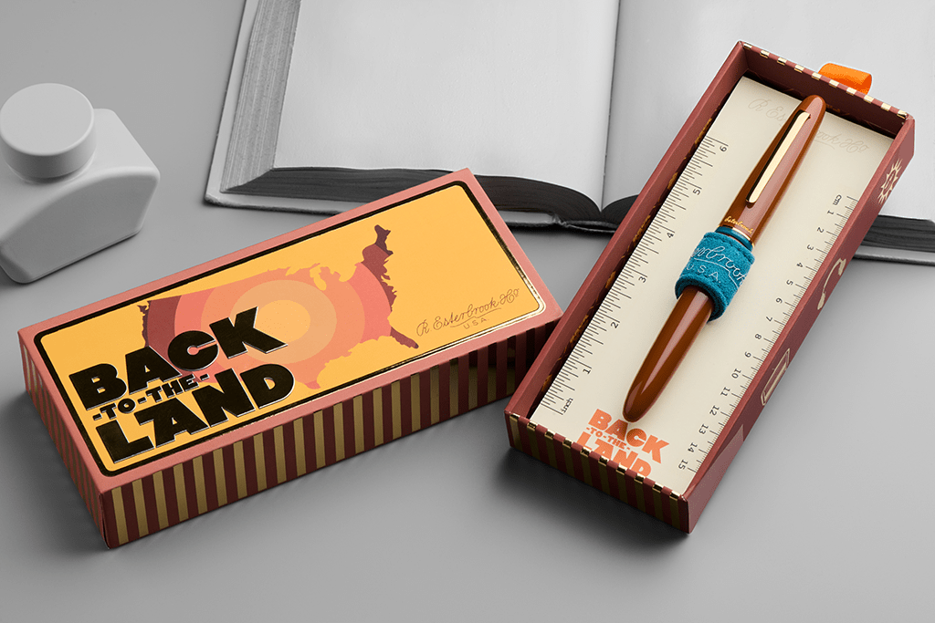 Brown pen with 'Back to the Land' packaging on a gray surface