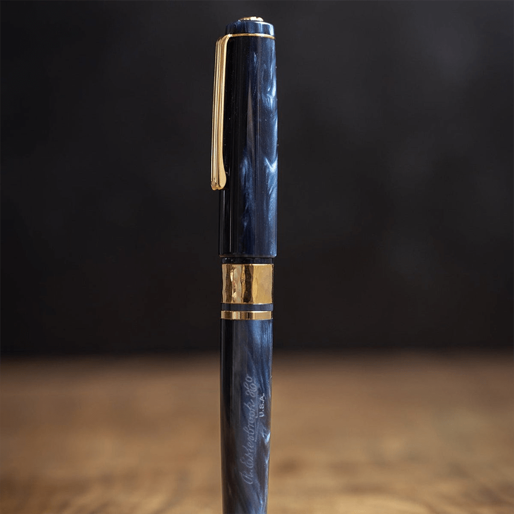 Blue pen with gold accents on a dark background