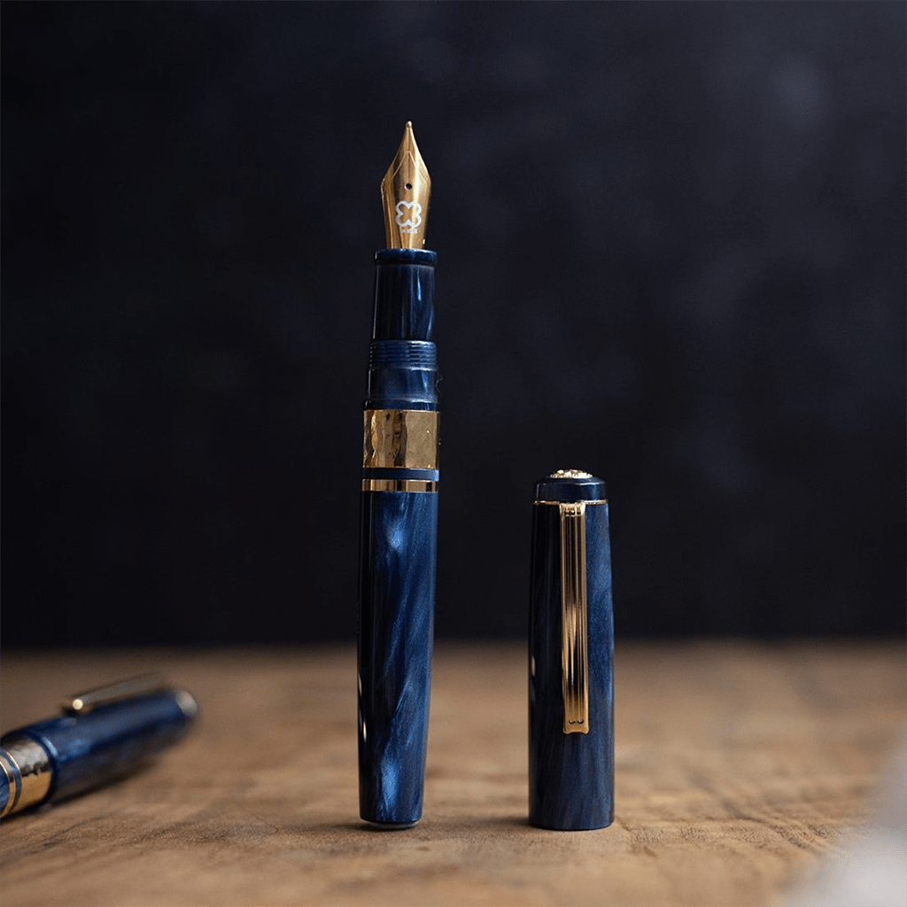 Blue fountain pen with gold accents on a wooden surface