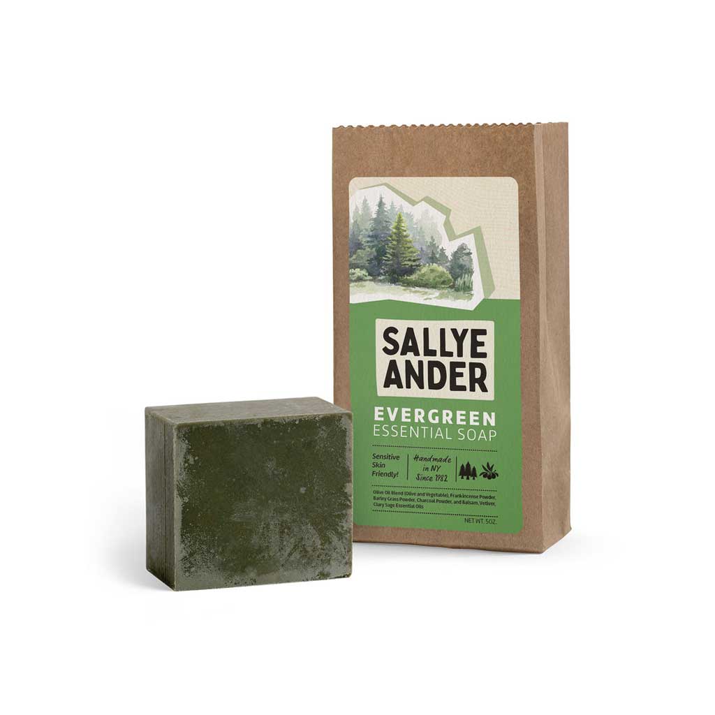 Dark green SallyeAnder evergreen essential soap next to packaging on white background