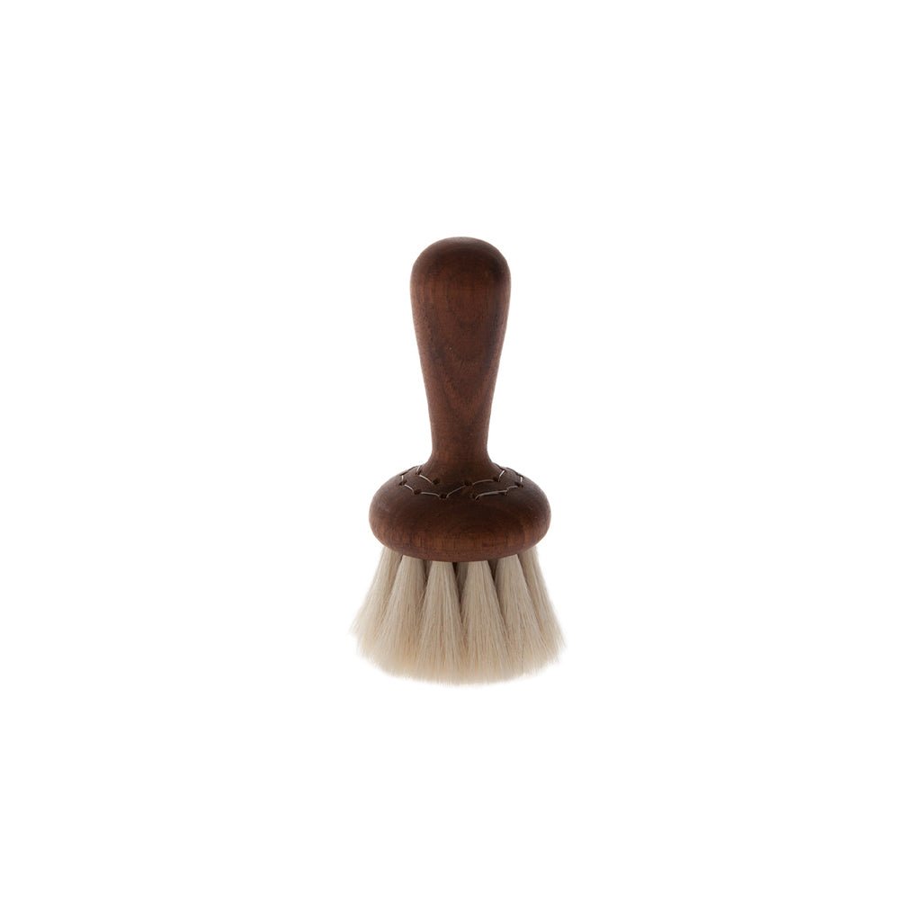 Small wooden face brush with light goat hair bristles on white background