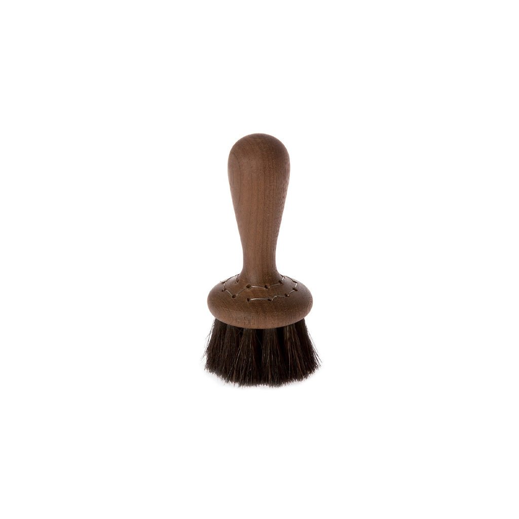 Small wooden face brush with dark horsehair bristles on white background