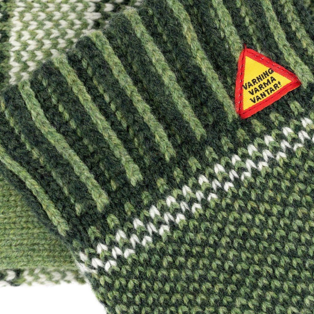 Green knitted fabric with a warning label on a white background