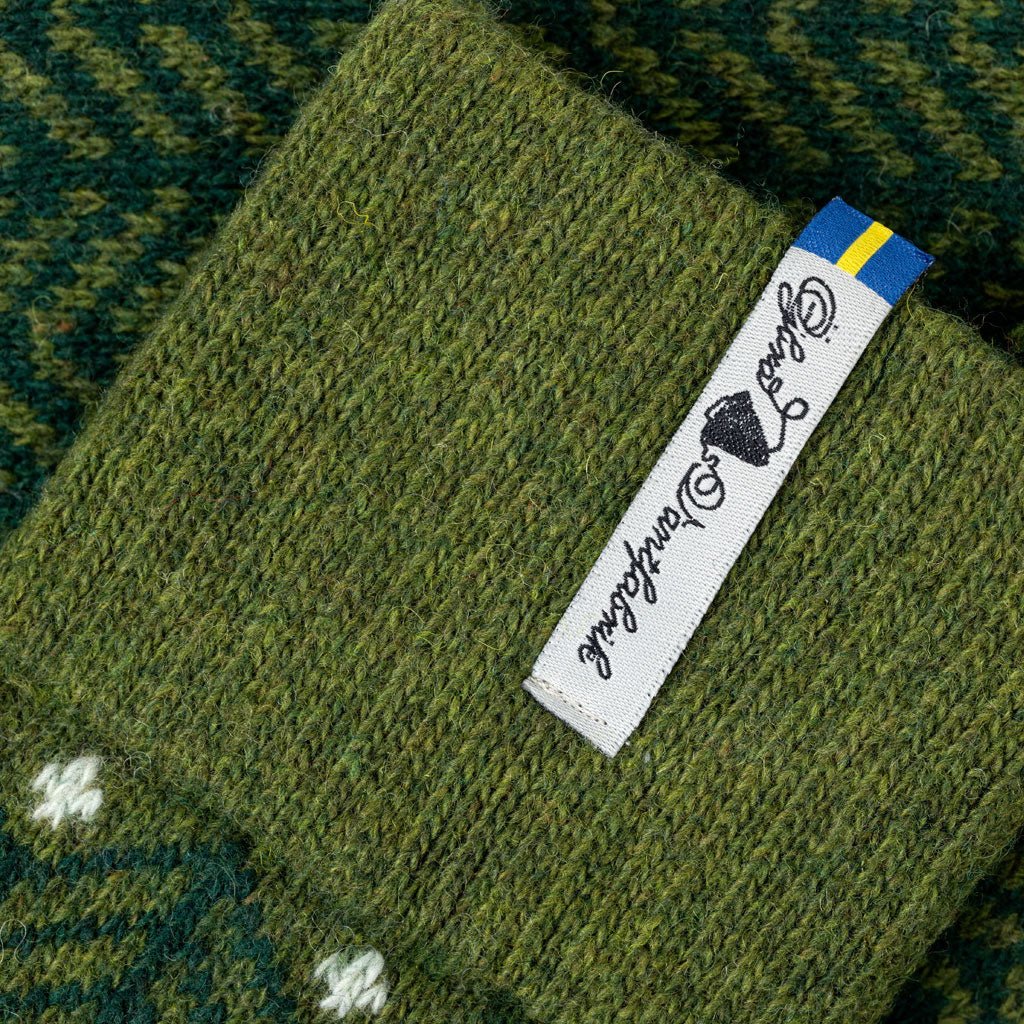 Green knitted fabric with a brand label on a textured background