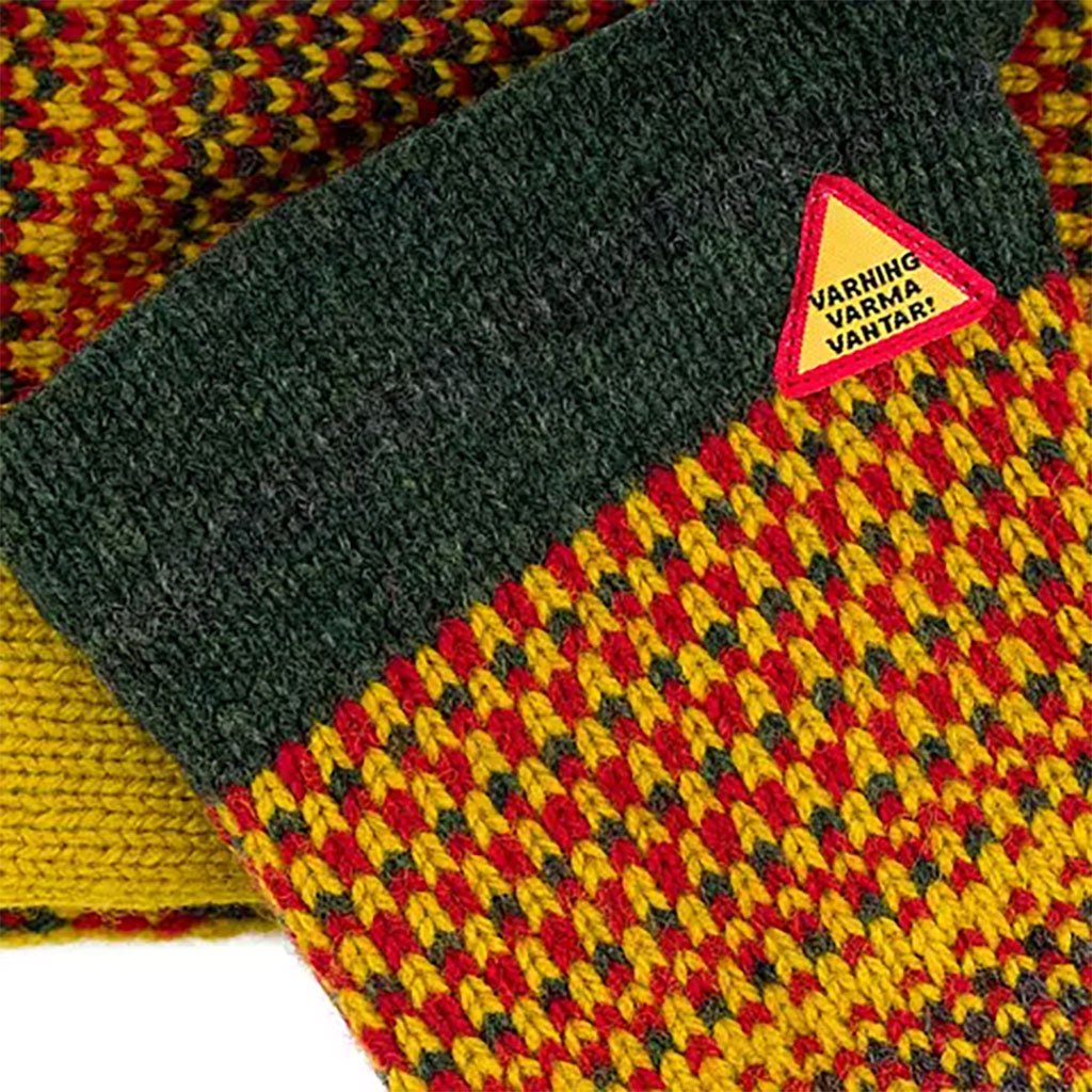 Knitted fabric with a triangular warning label on a patterned background