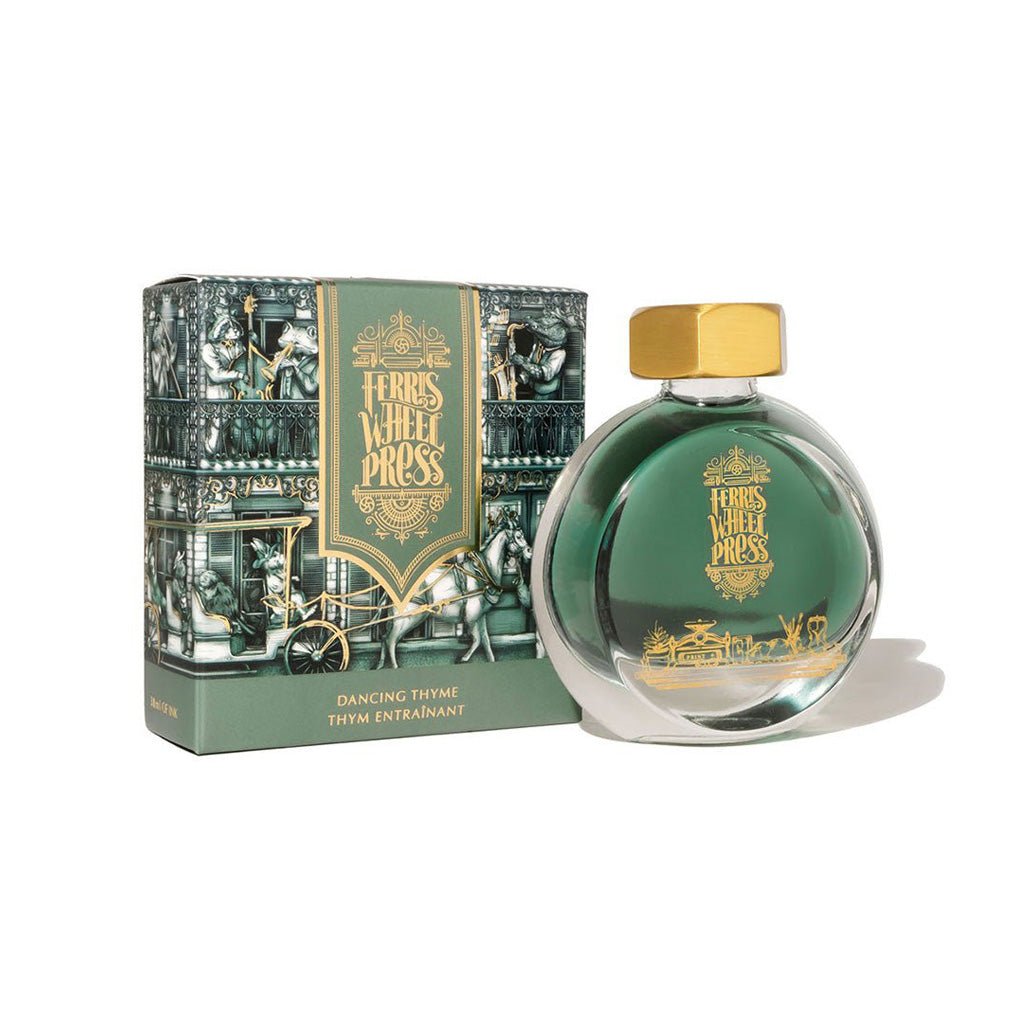 Green ink bottle with gold cap and decorative box on a white background
