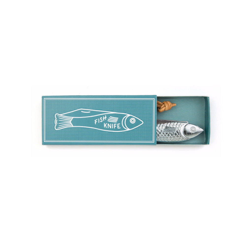 A novelty fish-shaped knife in a silver finish, presented inside its teal matchbox packaging with a white fish illustration on the lid.