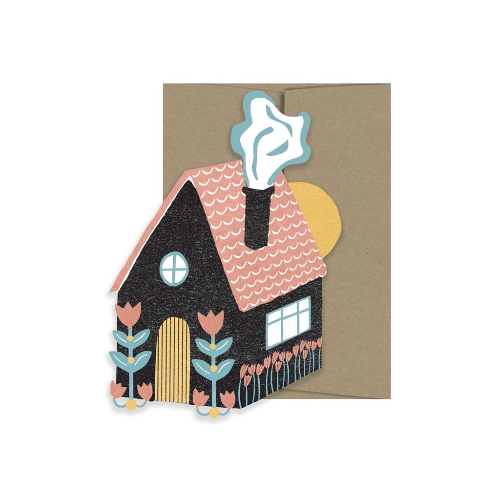 Folk-style house card with black home, flowers, and a chimney with smoke, paired with a kraft envelope.