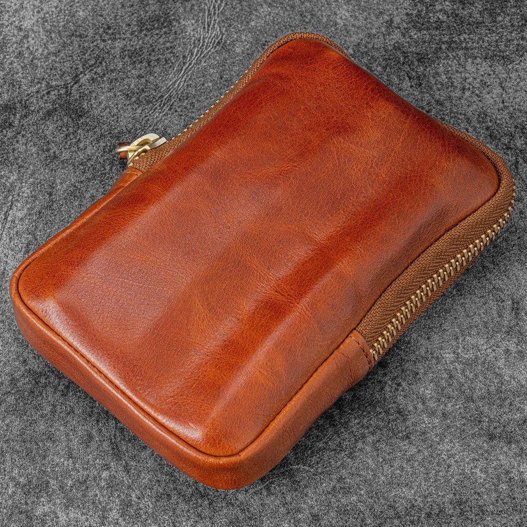 Brown leather zippered pen case on gray background