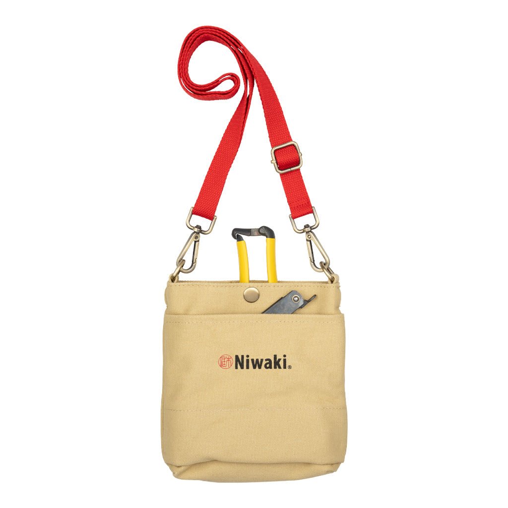 Beige canvas garden pouch with red strap and Niwaki branding with garden tools inside on white background