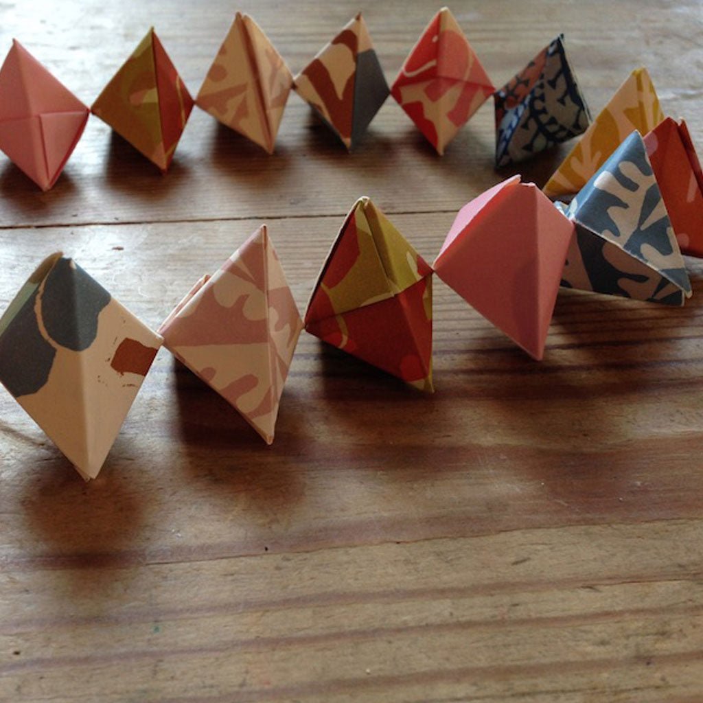 Colorful origami baubles arranged on a wooden surface