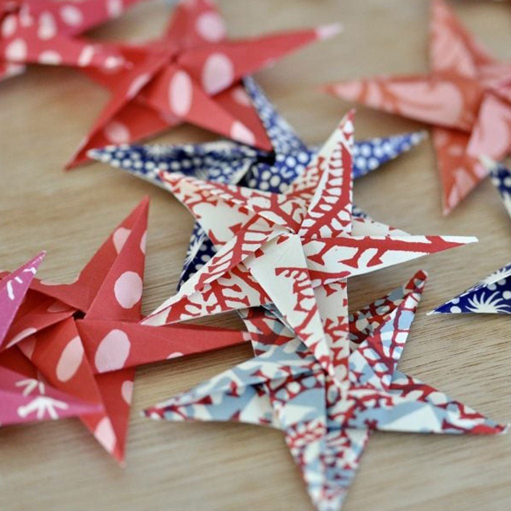 Colorful paper stars on a wooden surface