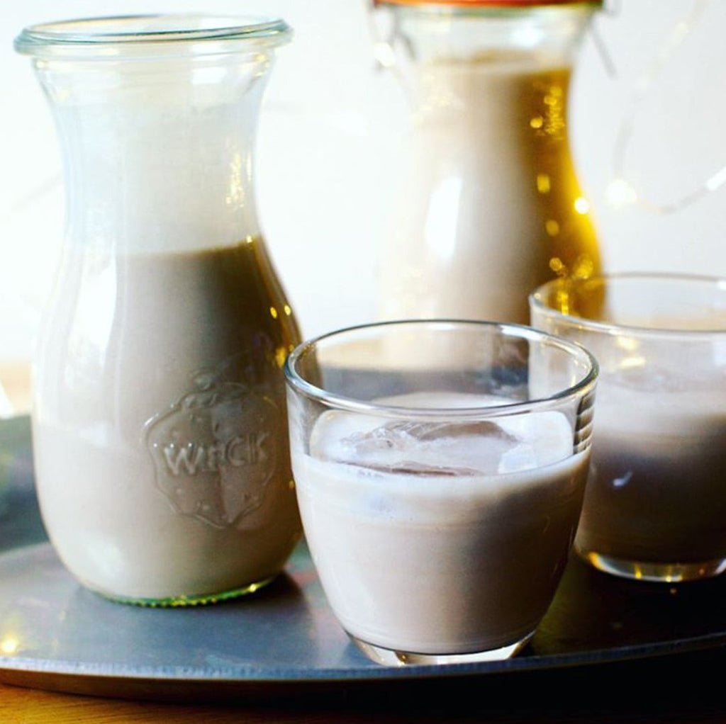 Glass jar and cups filled with a creamy drink on a tray