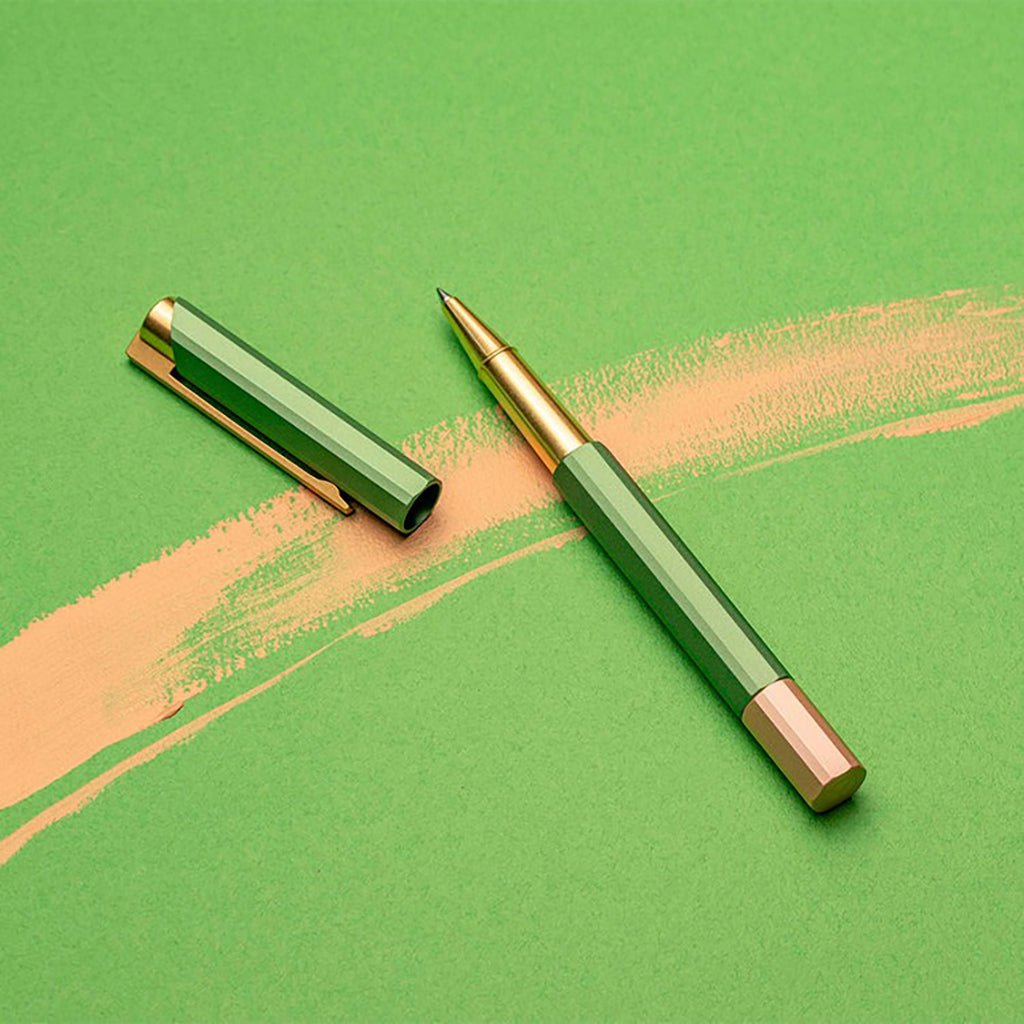 Green pen with rose gold accents on a green background