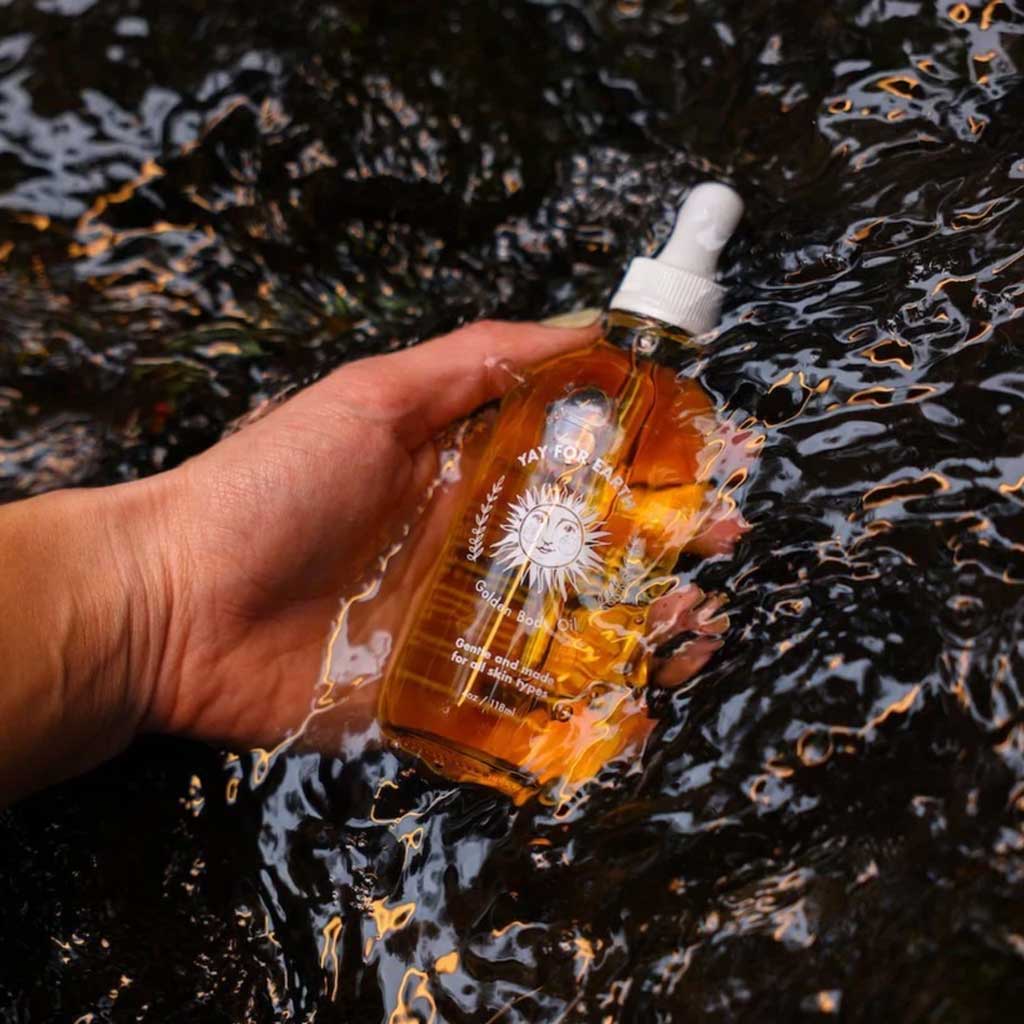 Hand holding a bottle with a dropper over water