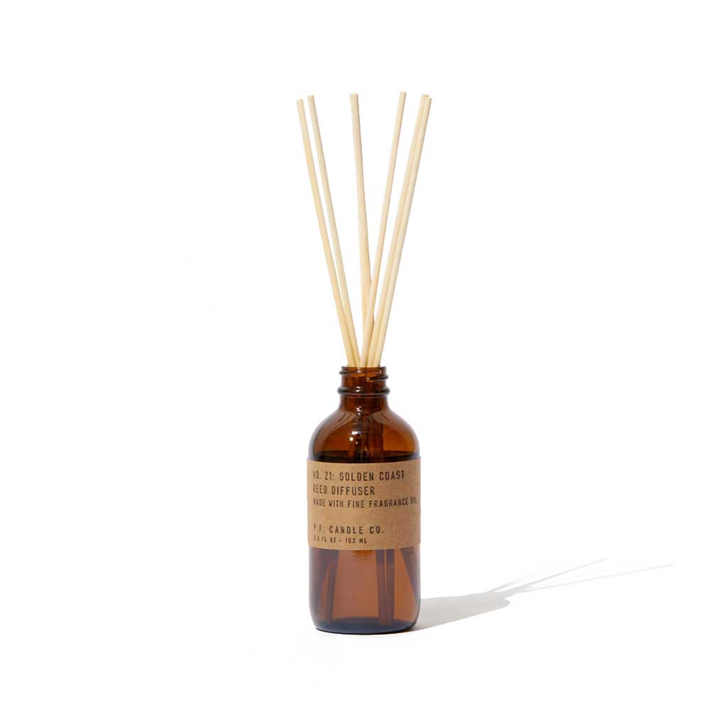 Amber glass diffuser bottle with wooden sticks on a white background