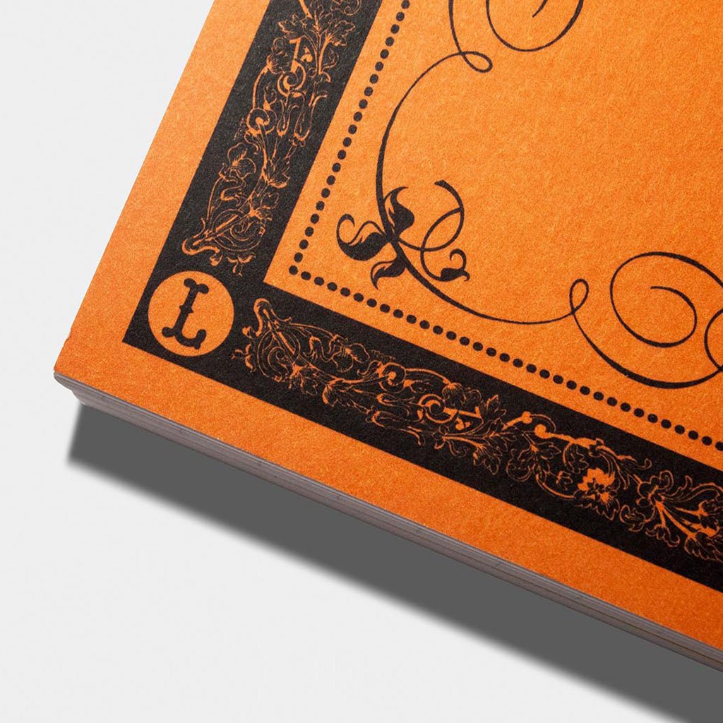 An orange Hand Lettering Guide Sheets pad on white background