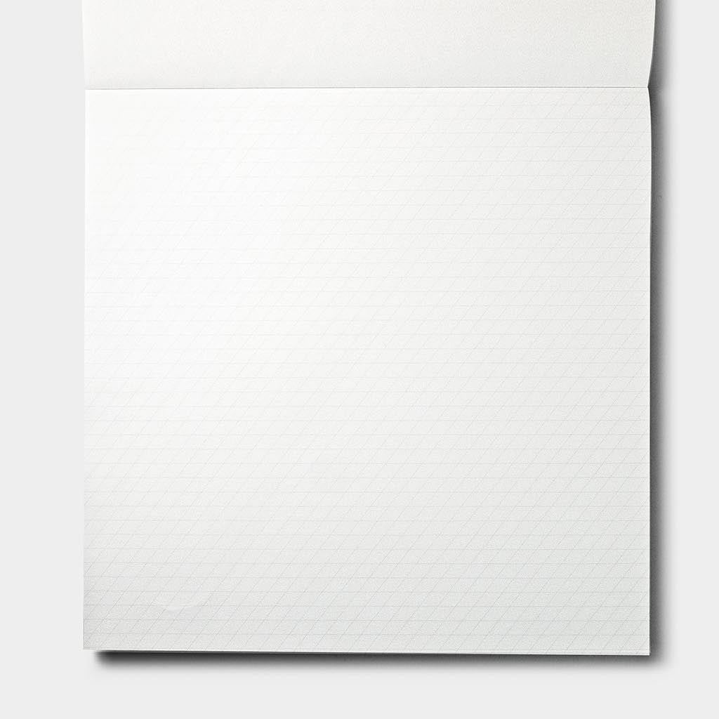 A close-up of a white textured paper sheet with a subtle grid pattern, shown against a light gray background.