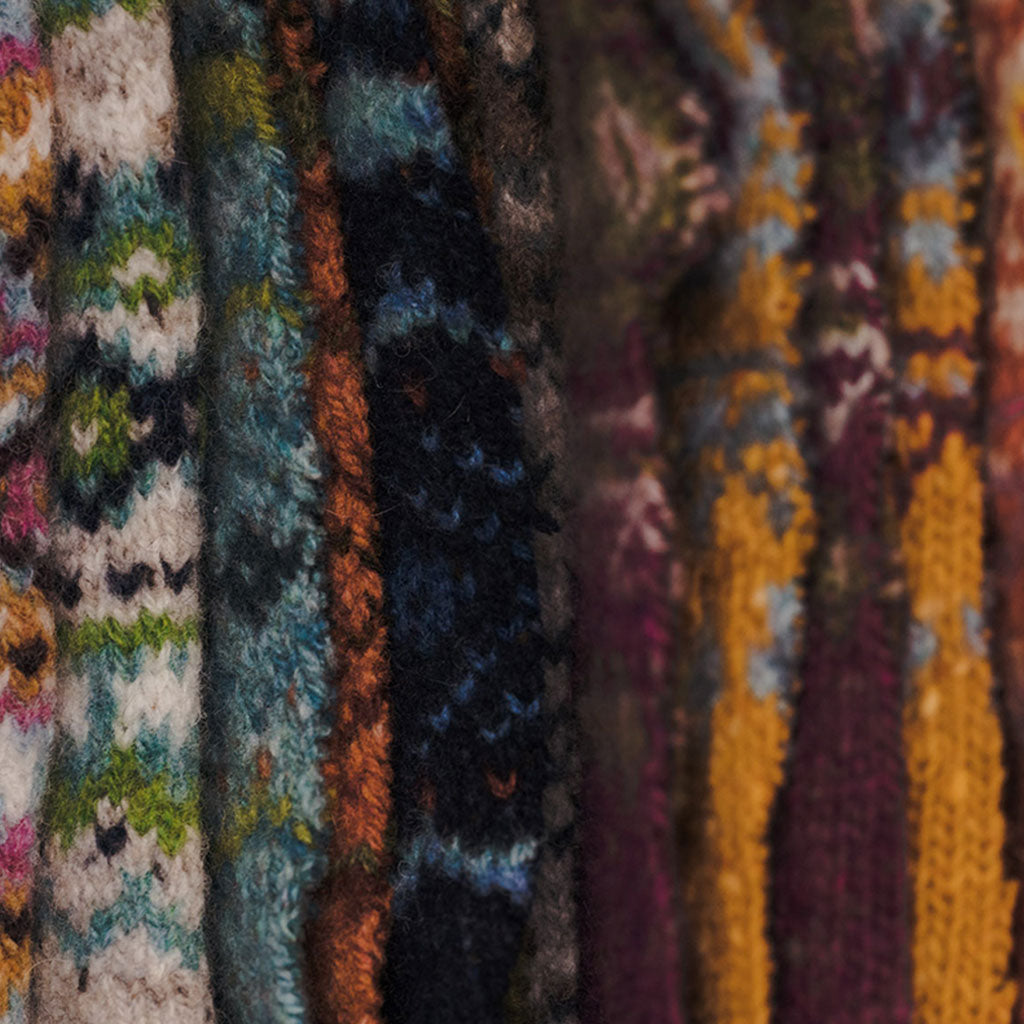 Close-up of various textured knitted wool fabrics in multicolors.