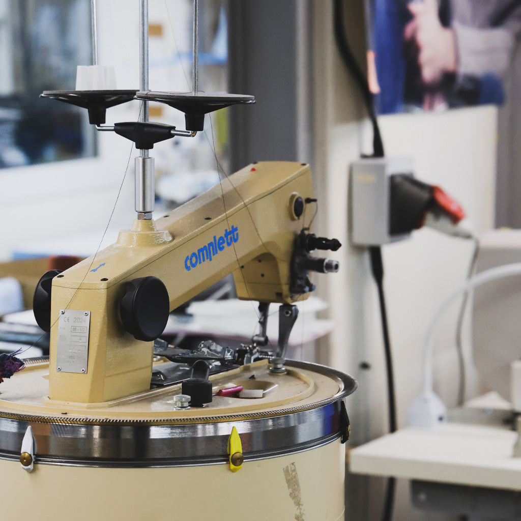 A beige industrial knitting machine.