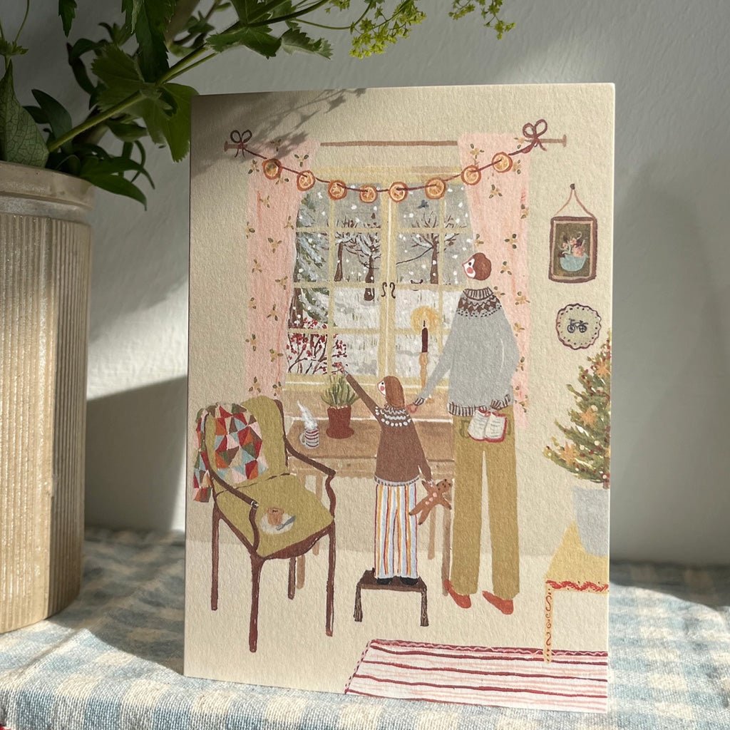 A holiday card on table with gingham tablecloth.