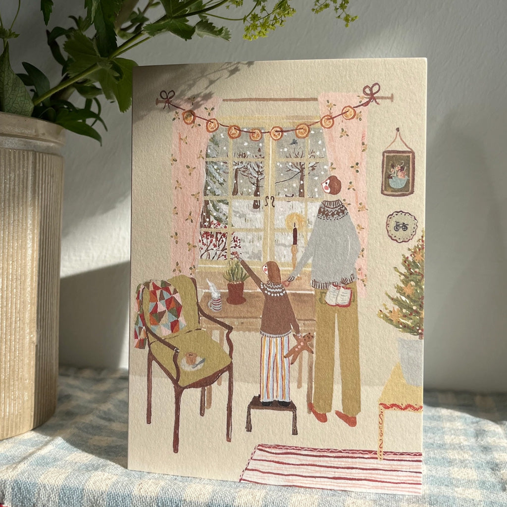 A holiday card on table with gingham tablecloth.